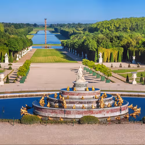 Panoramic view of the Versailles Park - the Latona Basin with the Grand Canal in the background under the summer sun, Versailles, France