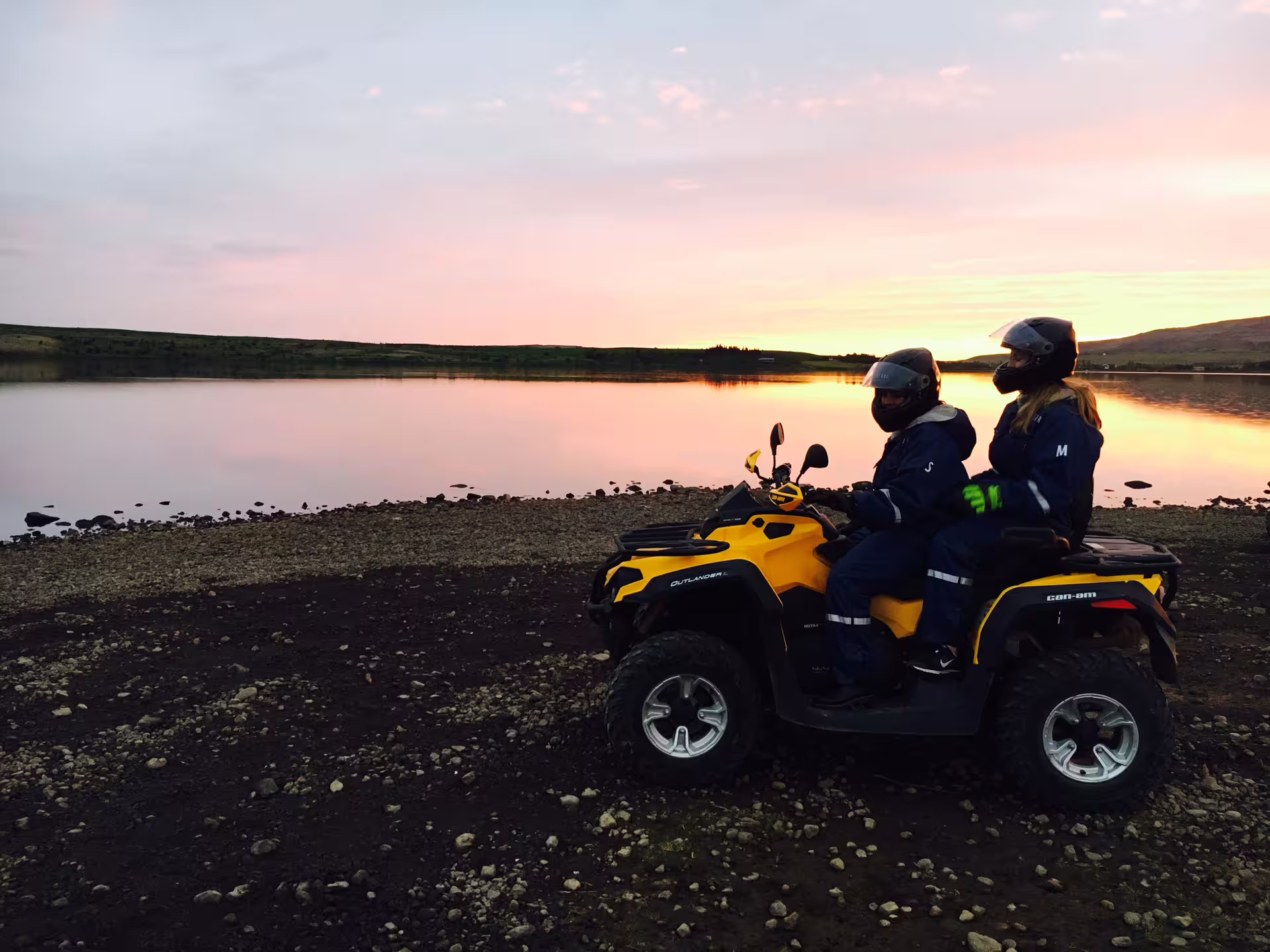 Riders enjoy a thrilling ATV adventure during the 2 Hour Midnight Sun Tour, set against a serene sunset by a tranquil lake.