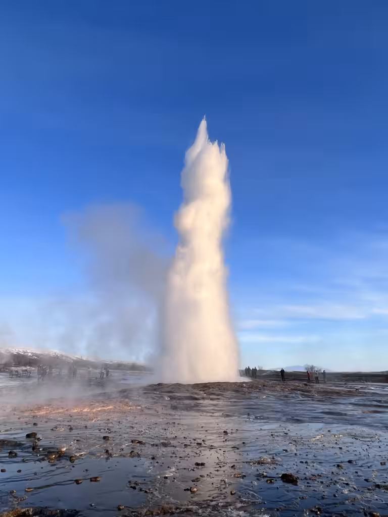 Spectacular geyser eruption under clear blue skies, a must-see on the 2026 Total Solar Eclipse Tour.