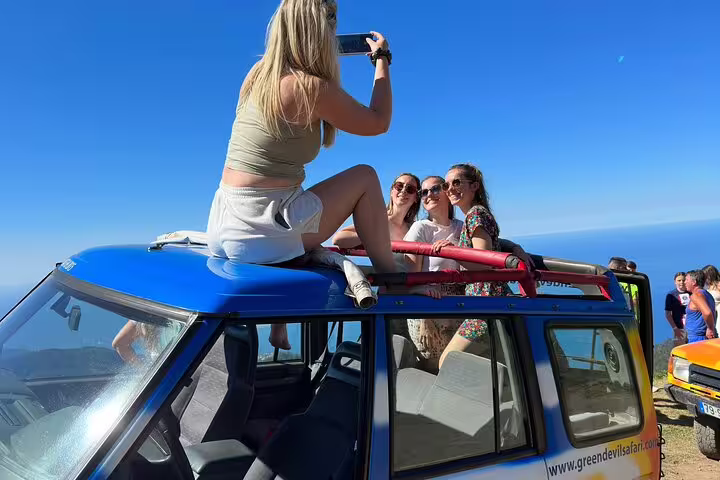 Tourists enjoying a scenic view on a 4x4 Jeep during a full-day adventure to Porto Moniz and Fanal, Madeira.
