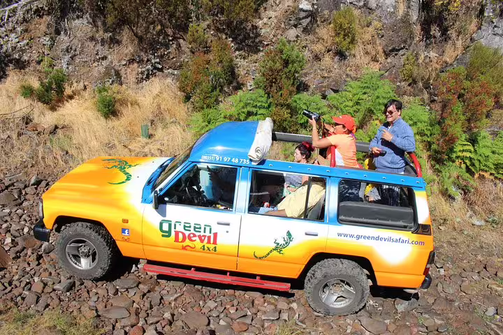 4x4 vehicle on rugged terrain with tourists exploring lush Northwest Terraces and Volcanic Pools on a scenic adventure tour.