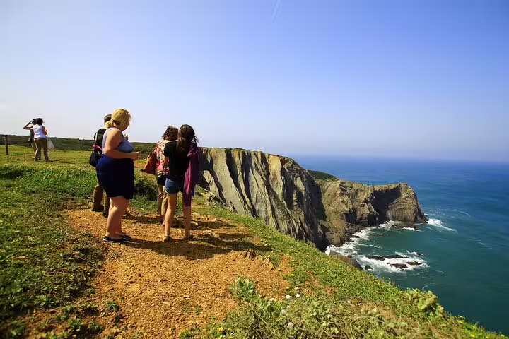 Tourists admire stunning ocean views from a cliffside trail on the 4x4 West Coast tour of the Natural Park.