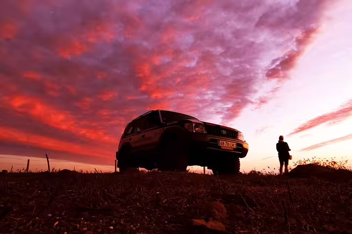 Off-road 4x4 vehicle at sunset with dramatic skies on the adventurous West Coast Natural Park tour.