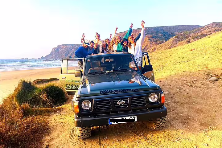 Group enjoying a 4x4 tour on the West Coast of the Natural Park, with stunning beach and cliff views.
