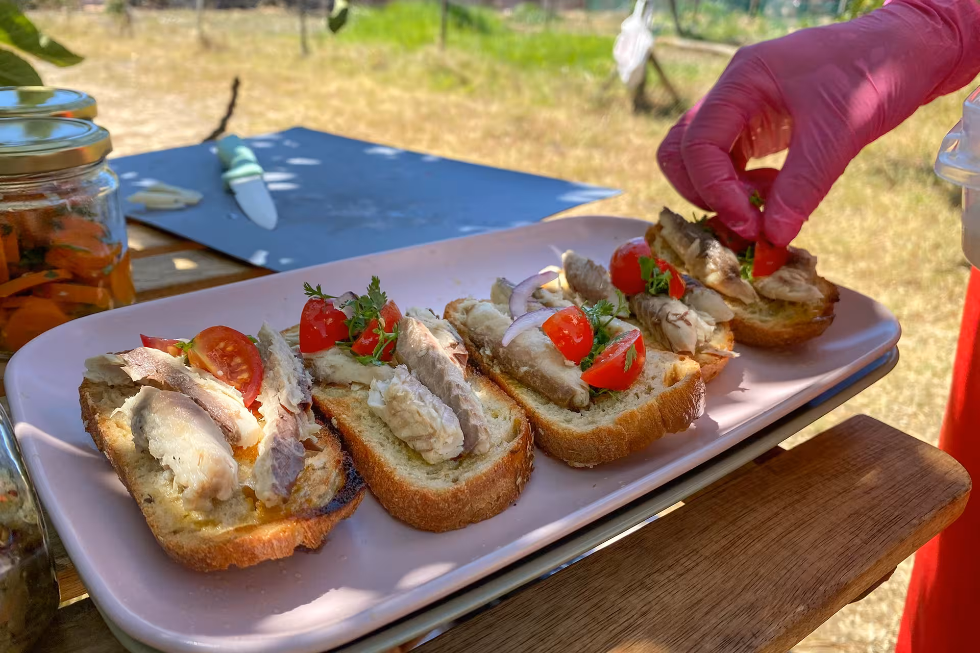 Fresh sardine and tomato bruschetta prepared outdoors on Algarve coast nature and food guided tour