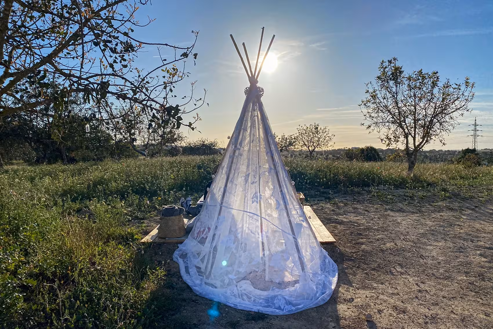 Elegant sheer tipi tent set up at golden sunset in Algarve vineyard for a private romantic dinner tour