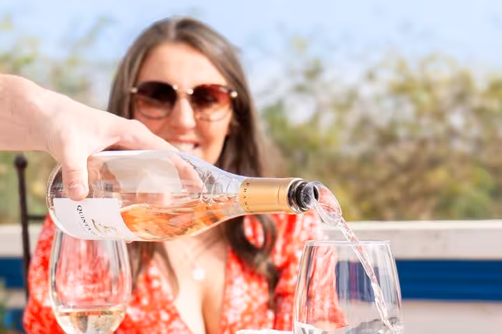 Smiling woman enjoying rosé wine being poured outdoors during Albufeira wine tasting tour at historic Silves boutique winery