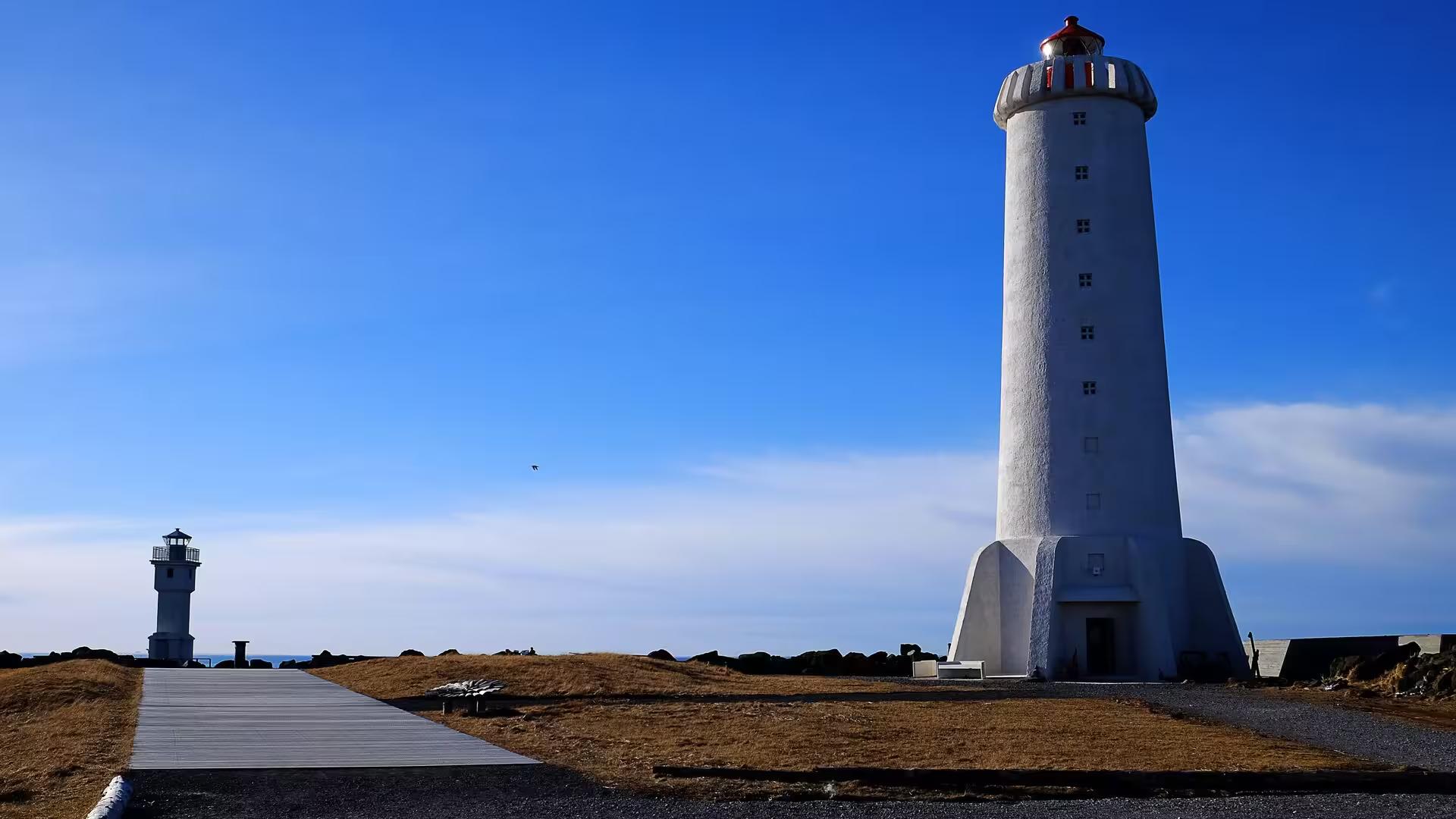 Iconic white Reykjavik lighthouse under a clear blue sky on an Elves and Nature guided driving tour in Iceland