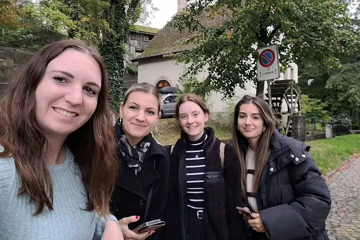 Friends take a selfie on the Aarau scavenger hunt self-guided tour near a historic watermill path