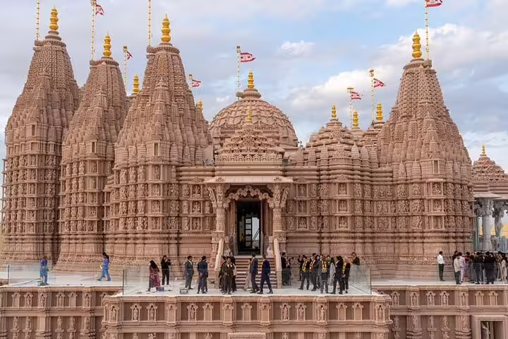 Visitors explore the ornate facade of a Hindu temple, a highlight of the Abu Dhabi city tour experience.