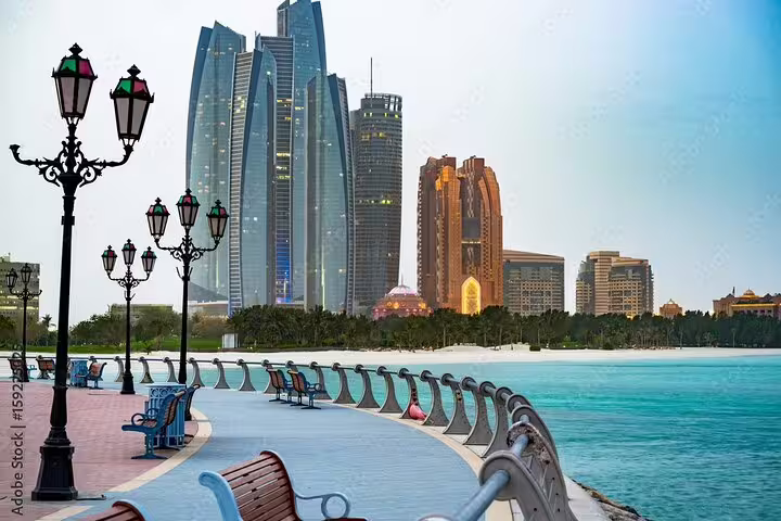 Scenic view of Abu Dhabi's Corniche with iconic skyscrapers and a serene coastal promenade, ideal for city tours.