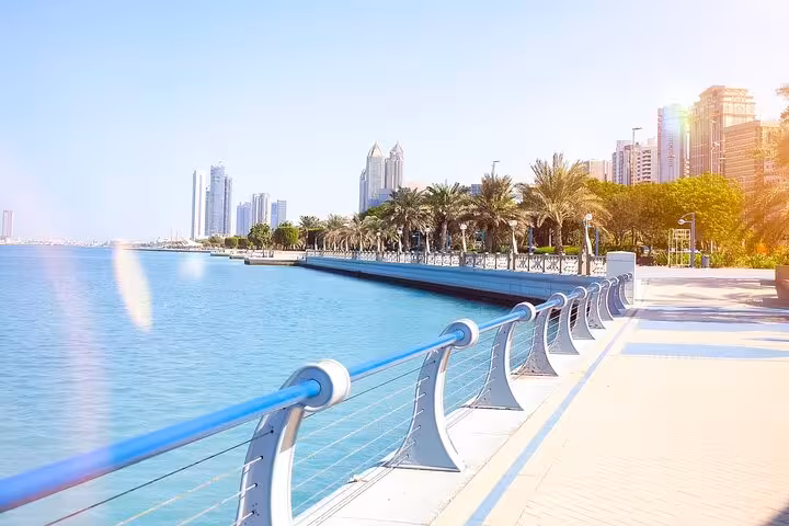 Abu Dhabi Corniche promenade with skyline views and turquoise sea, featured on a private full-day city tour