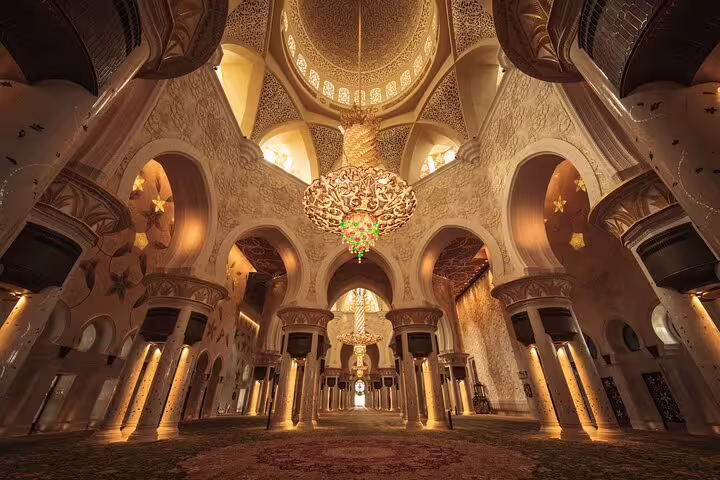 Ornate interior of Sheikh Zayed Grand Mosque in Abu Dhabi, showcasing grand chandeliers and intricate architectural design.