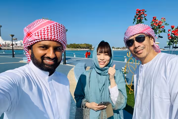 Tour guests with local guide on Abu Dhabi Corniche during city tour with Grand Mosque and Qasr Al Watan