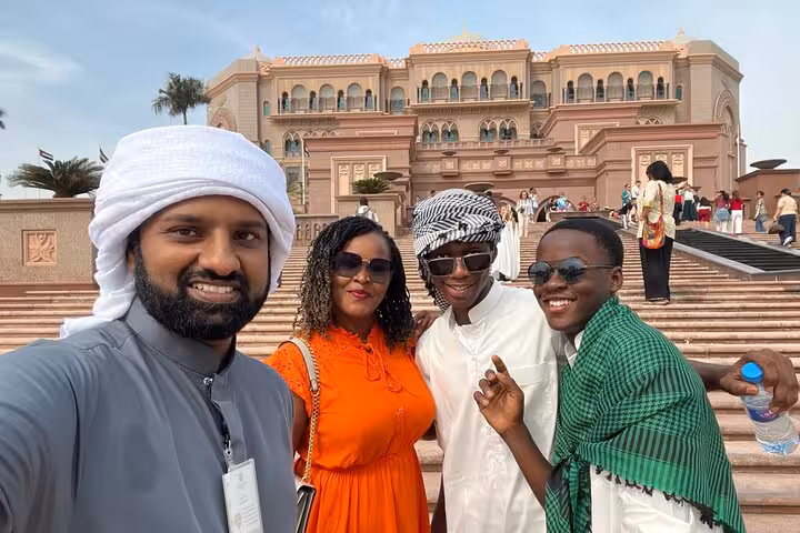 Tourists at Qasr Al Watan Abu Dhabi on city tour, group photo on palace steps with mosque entry included