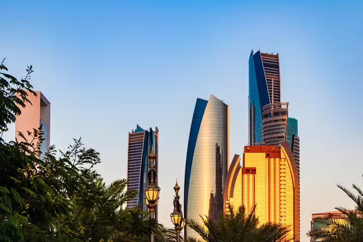 Abu Dhabi skyline towers at sunset, scenic stop on Dubai private day tour to Sheikh Zayed Mosque and Palace