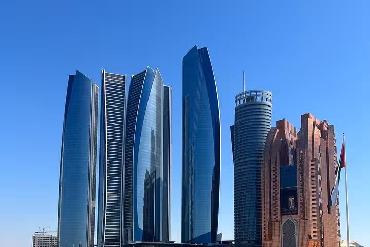 Etihad Towers skyline view in Abu Dhabi on city tour with Ferrari World ticket, modern skyscrapers under blue sky