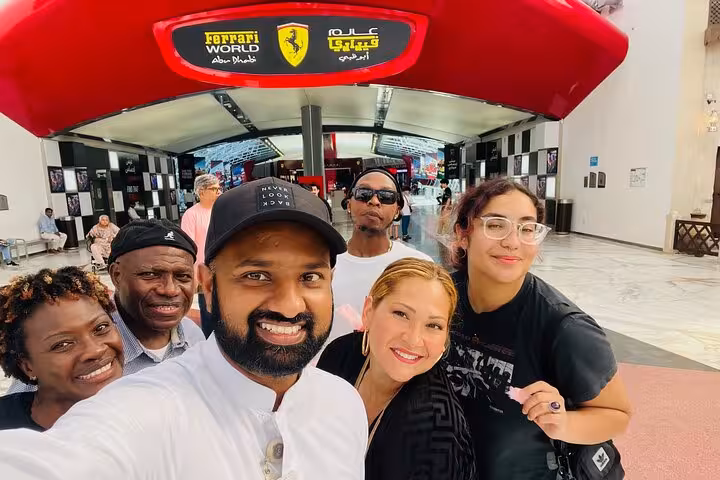 Private Abu Dhabi city tour group selfie at Ferrari World entrance, ideal stop on Sheikh Zayed Mosque itinerary
