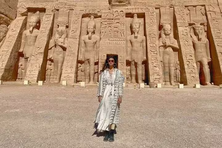 Traveler posing at Abu Simbel Great Temple facade on Luxor to Aswan day tour with Abu Simbel visit