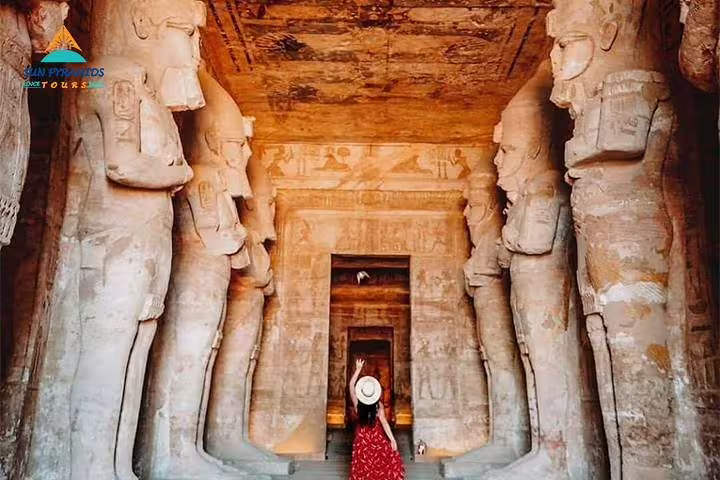 Visitor in Abu Simbel temple corridor with colossal statues on 8 days 7 nights Cairo to Abu Simbel road tour