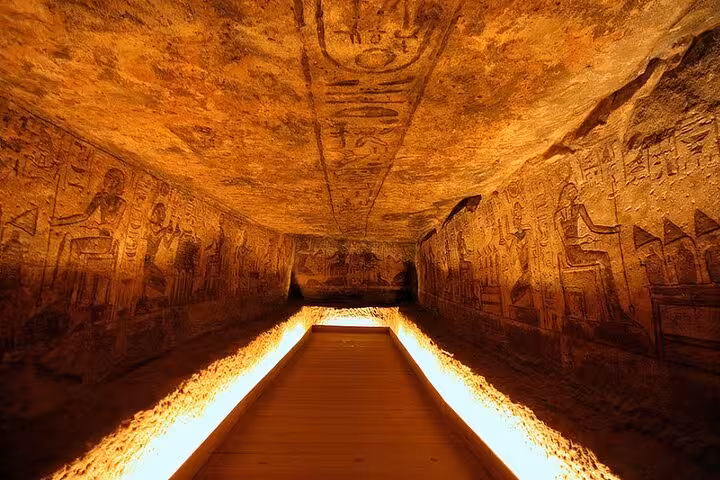 Illuminated corridor with ancient hieroglyphs inside Abu Simbel Temple on private full-day tour from Aswan