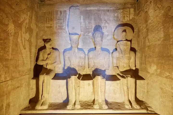 Interior sanctuary of Abu Simbel Temple with seated gods and carvings, guided day tour from Aswan