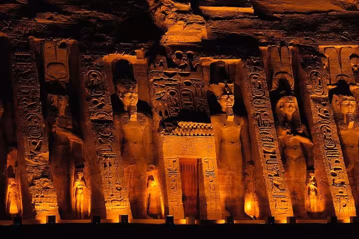 Illuminated Abu Simbel Temple at night with carved pillars, featured on private full-day tour from Aswan