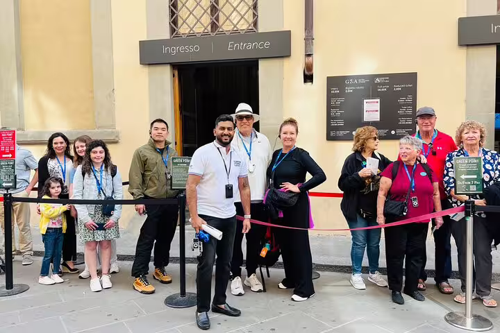 Happy small group with expert guide at priority entrance to Florence Academia Gallery for VIP David tour