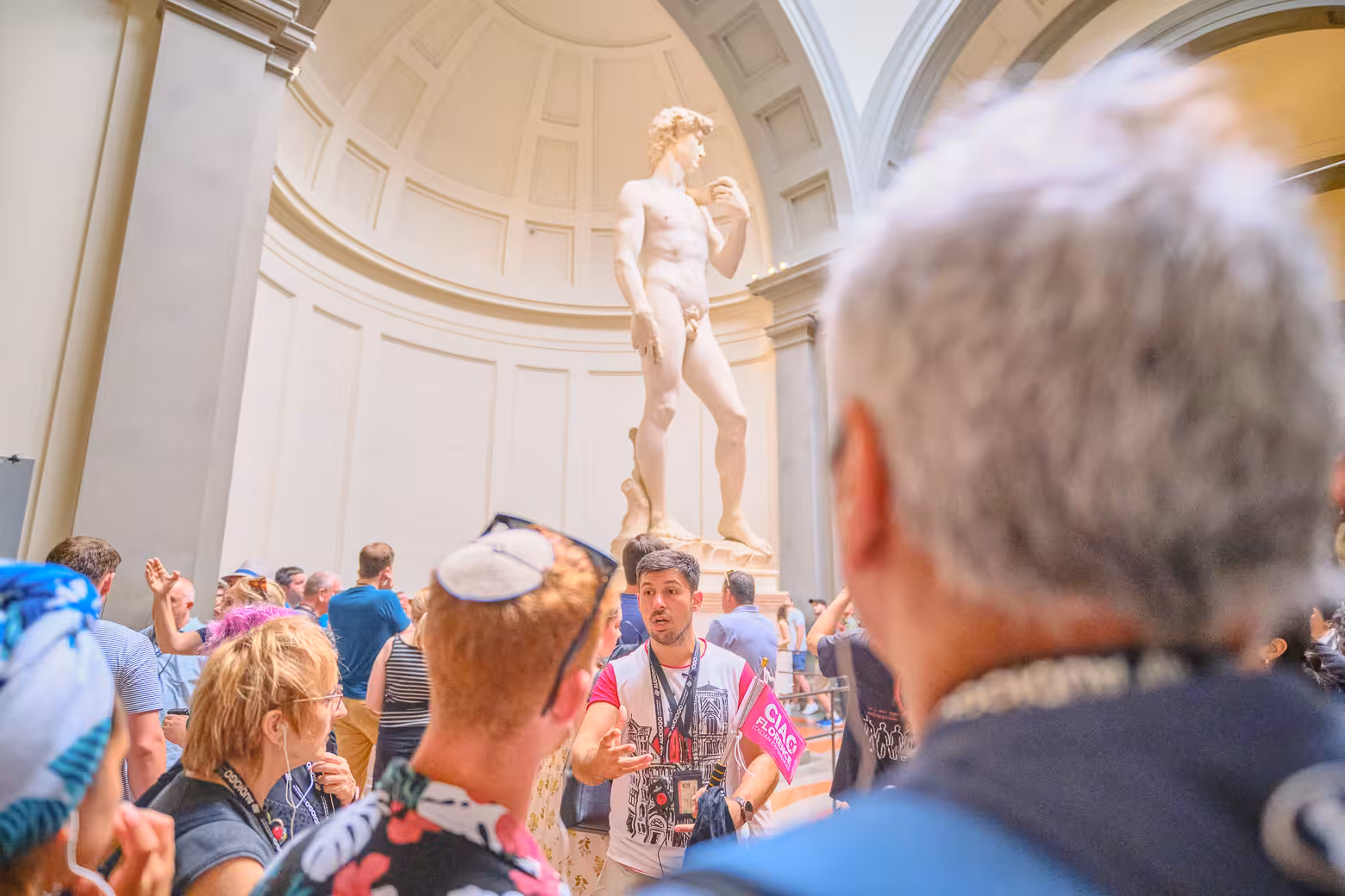 Crowd gathers around David statue on Accademia Gallery guided tour in Florence.