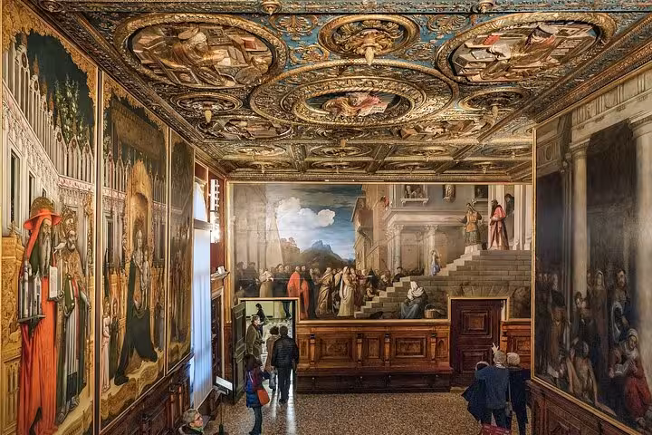 Ornate gallery room in Accademia Gallery with intricate frescoes and visitors exploring the art.