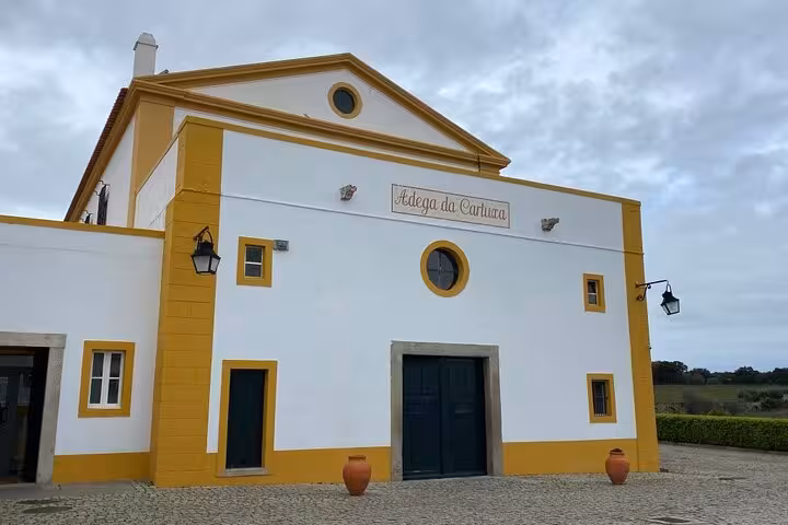Facade of Adega da Cartuxa winery near Évora, featuring classic architecture and picturesque countryside surroundings.