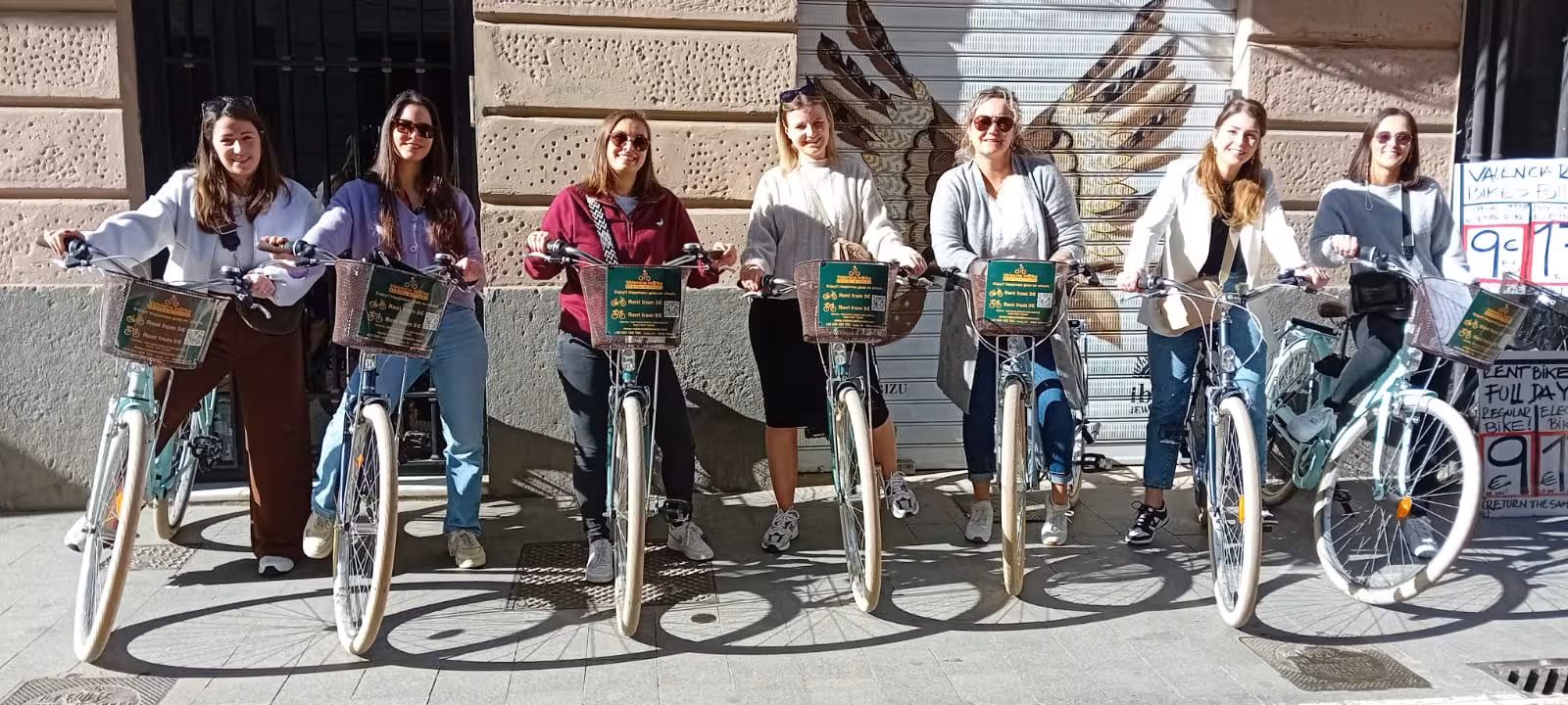Smiling group lined up with adult city bike rentals on a downtown street, great for easy urban bike rides