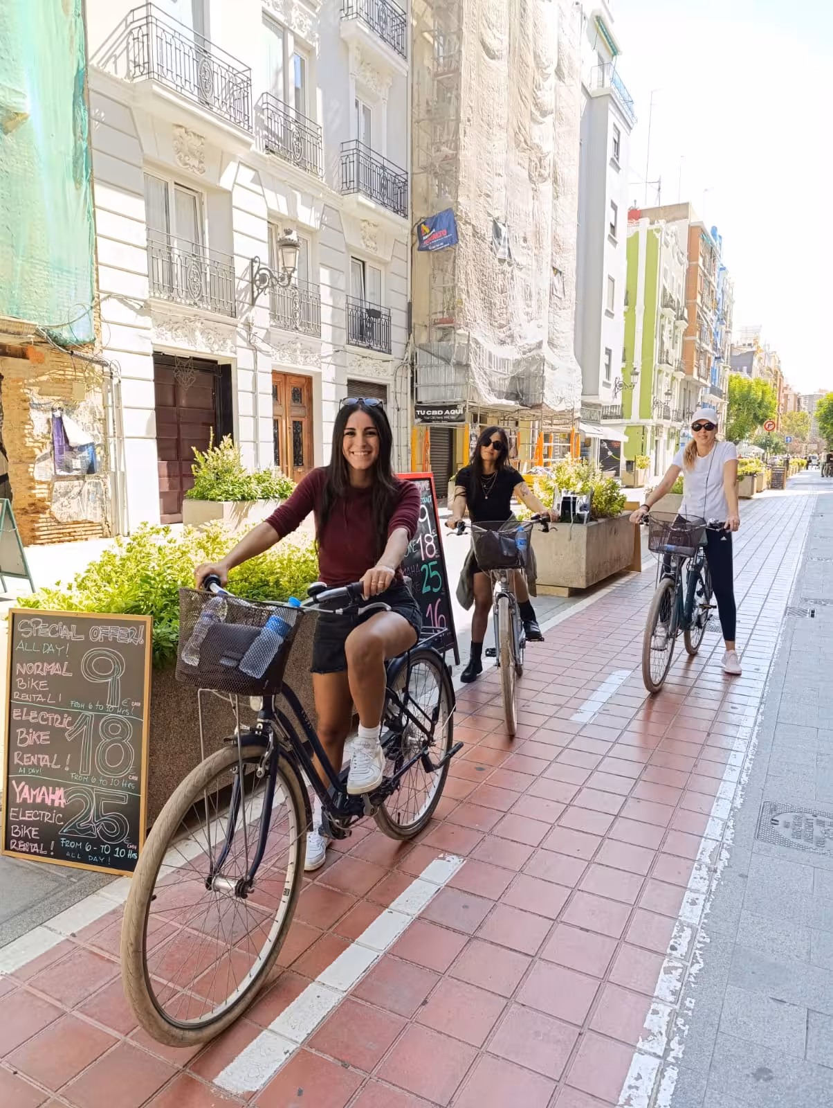 Adults riding rental city bikes on a sunny downtown street, ideal for self-guided urban cycling tours