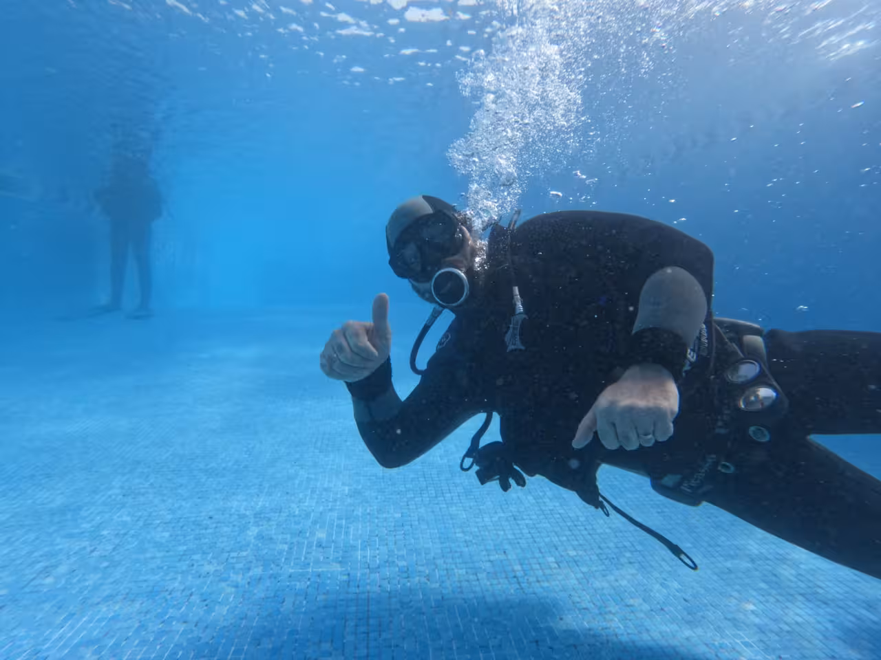 Advanced scuba diver practicing buoyancy skills in a clear training pool, perfecting techniques for deep adventure dives