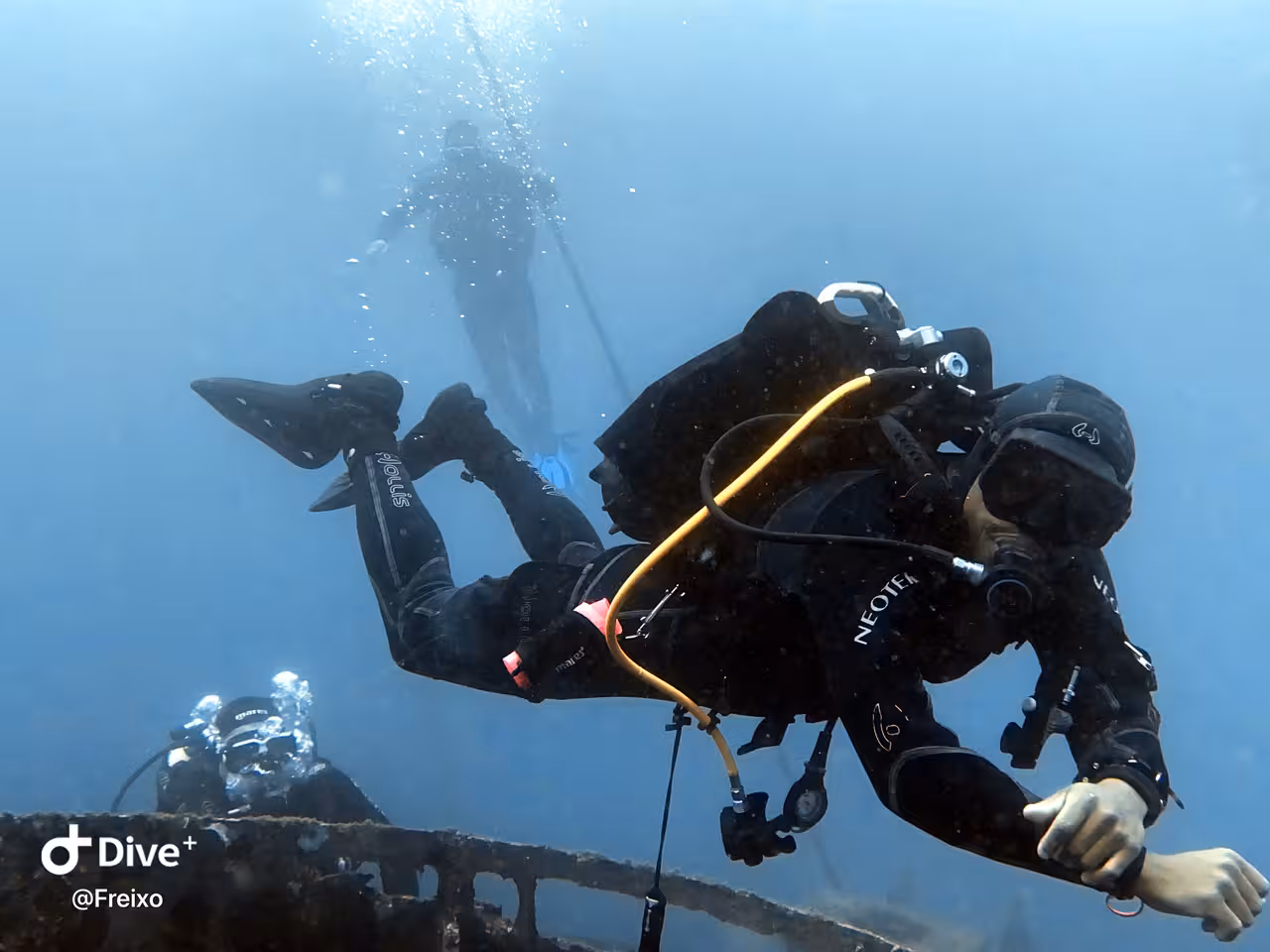 Experienced scuba diver explores a shipwreck site with full gear during an advanced open-water wreck diving excursion