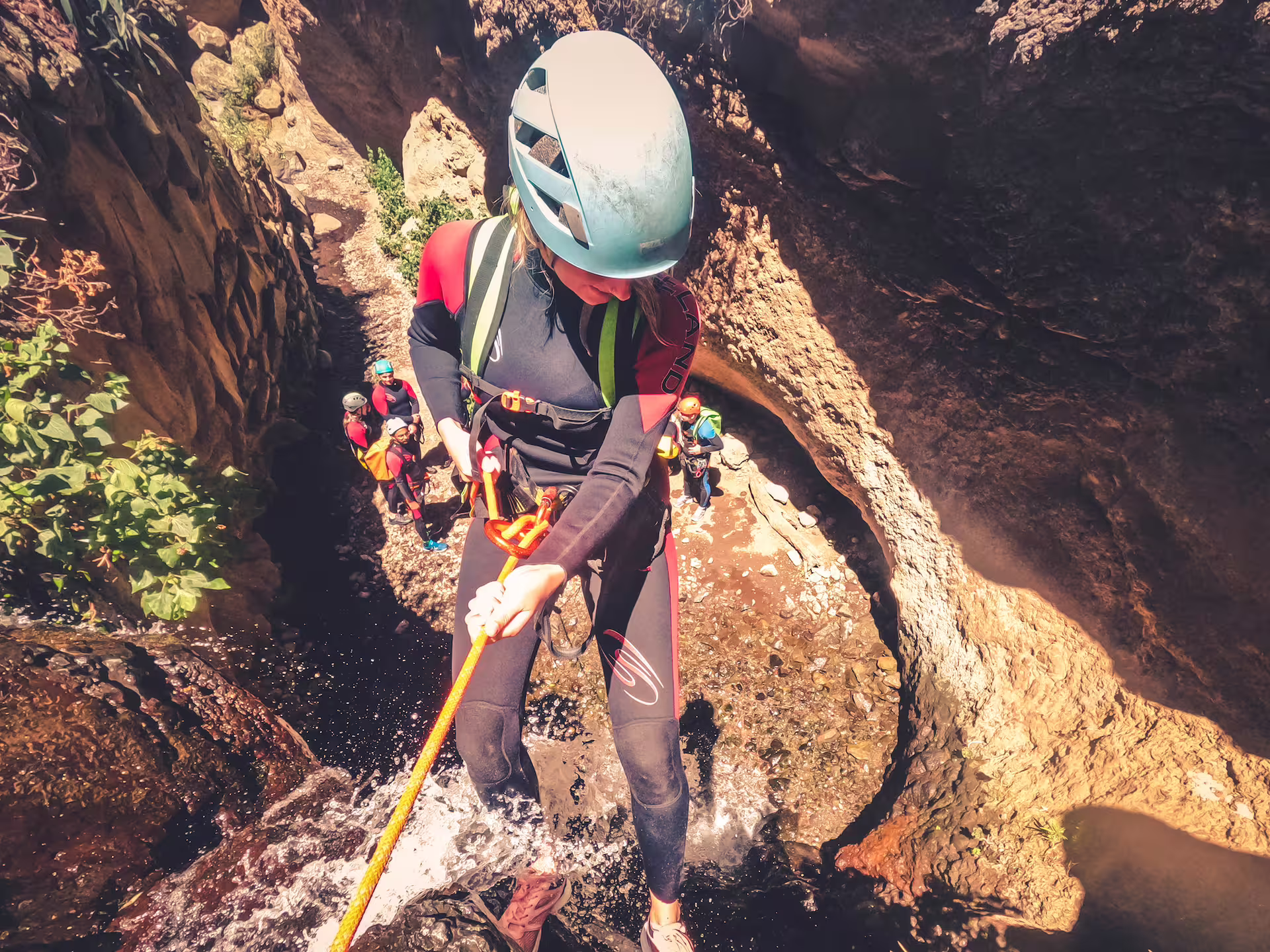 Adventurer descends a waterfall during an exhilarating canyoning tour in the lush rainforest.