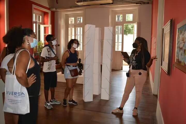 Visitors engage with Afro-Brazilian art guided tour in a vibrant Rio gallery in Little Africa.