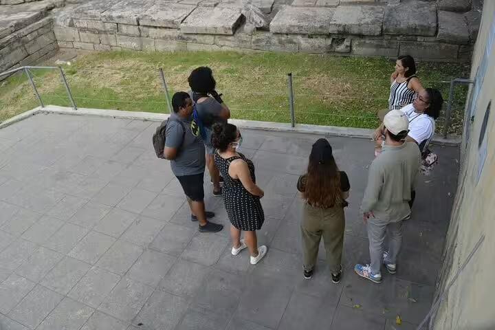 Group of tourists exploring Afro-Brazilian heritage in Little Africa, Rio, with ancient stone ruins in the background.