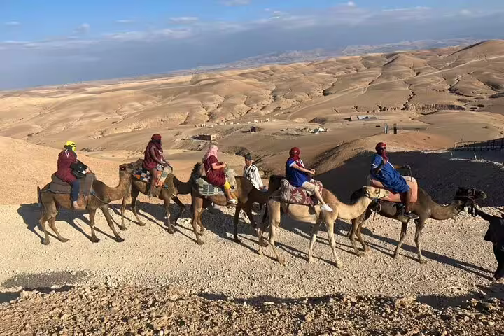 Caravan camel trek across Agafay Desert hills near Marrakech, included in quad tour with dinner show