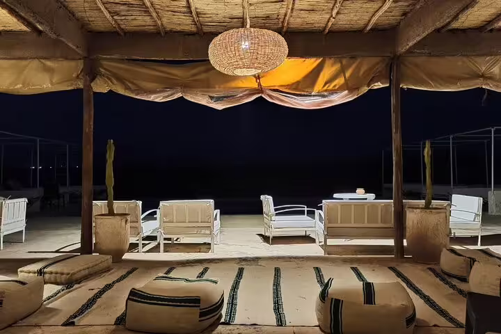 Agafay Desert dinner camp lounge at night with Moroccan rugs and seating after quad and camel tour