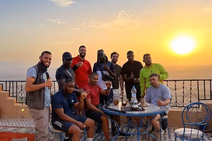 Group enjoying sunset tea on a terrace in Marrakech after an adventurous day in the Agafay Desert.