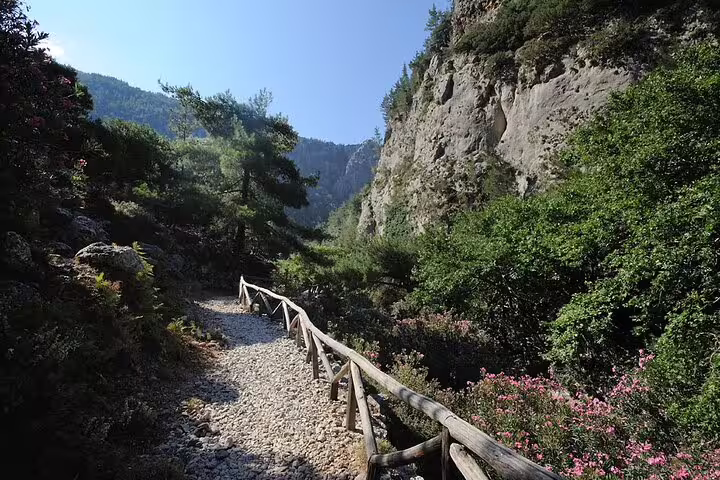 Scenic Agia Irini Gorge trail with lush greenery and rugged cliffs, ideal for adventurous hikers.