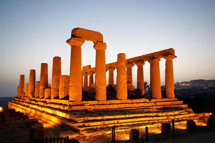 Illuminated Greek temple ruins at dusk in the Valley of the Temples, Agrigento, on a 2-hour private guided tour