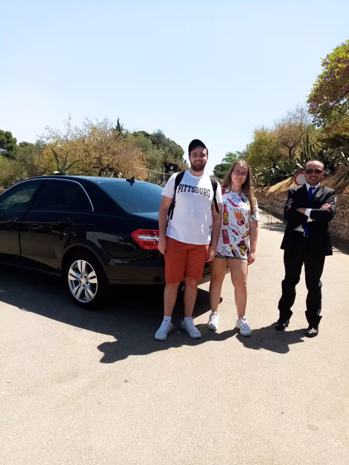 Couple with private driver beside luxury car on Agrigento day trip from Palermo to Valley of the Temples and Scala dei Turchi