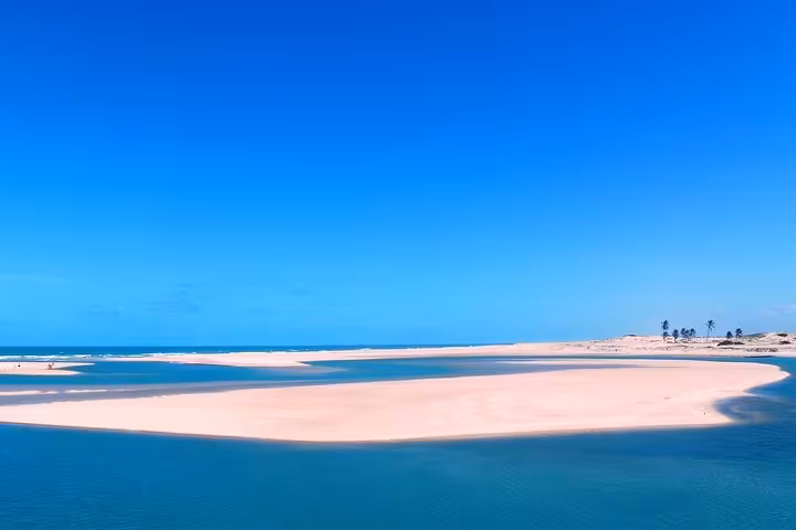 Águas Belas Tour view of pristine sandbanks and turquoise lagoon meeting the Atlantic under clear blue sky