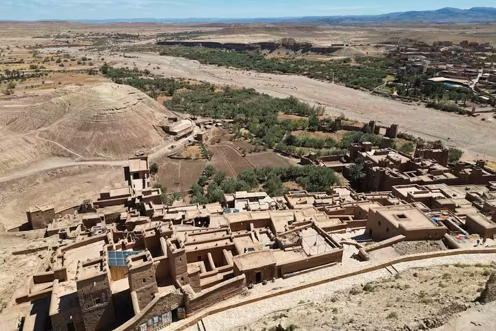 Aerial view of Ait Benhaddou's ancient kasbahs surrounded by desert landscape on a 3-day Marrakech to Fes tour.