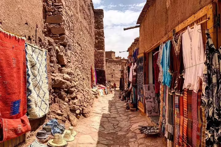 Souk alley in Ait Benhaddou kasbah with Berber rugs and crafts on a private day trip from Marrakech