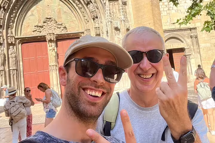 Two travelers selfie by Aix-en-Provence cathedral doors on a scavenger hunt and sights self-guided tour