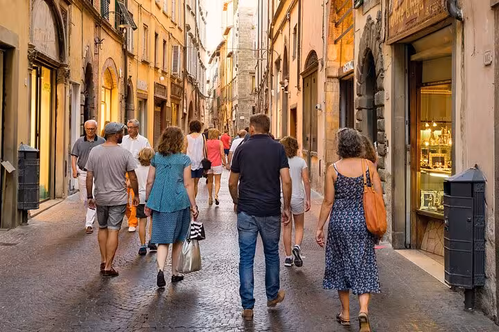 Tourists strolling along a charming cobblestone street in the heart of Aix-en-Provence's shopping district.