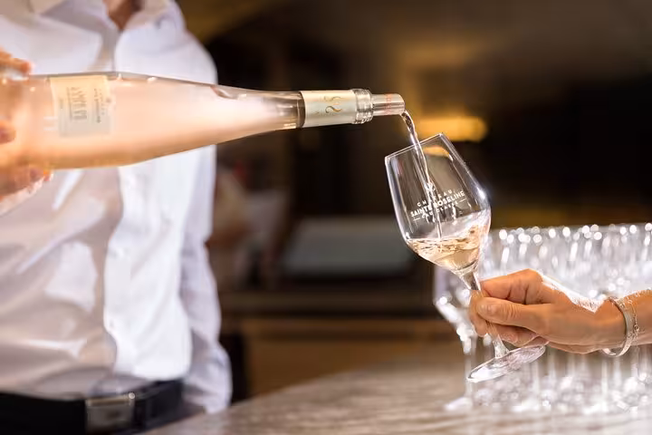A sommelier pours rosé wine into a glass at a tasting event on the Aix En Provence private full-day wine tour.